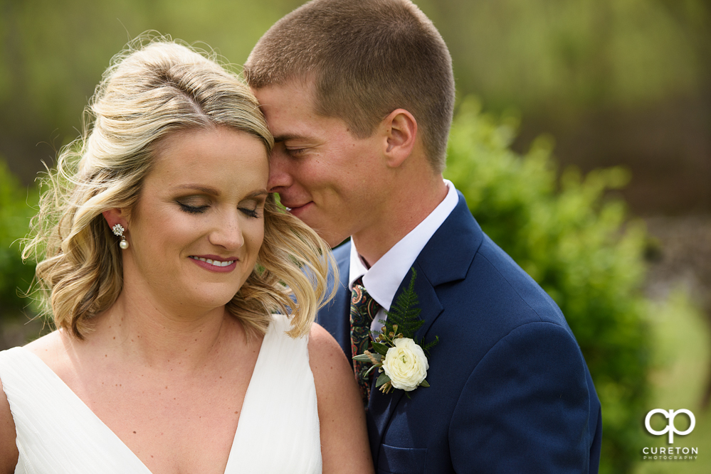Bride and groom snuggling after their wedding at Greenbrier Farms in Easley, SC.