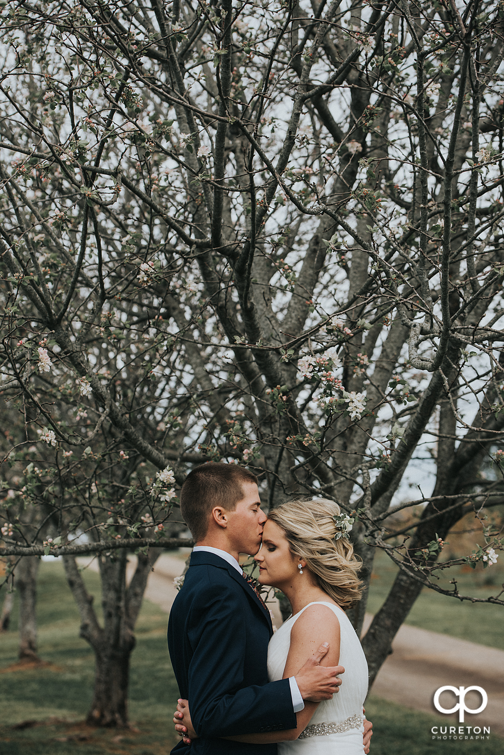 Groom kissing his bride on the cheek before their Greenbrier Farms wedding.
