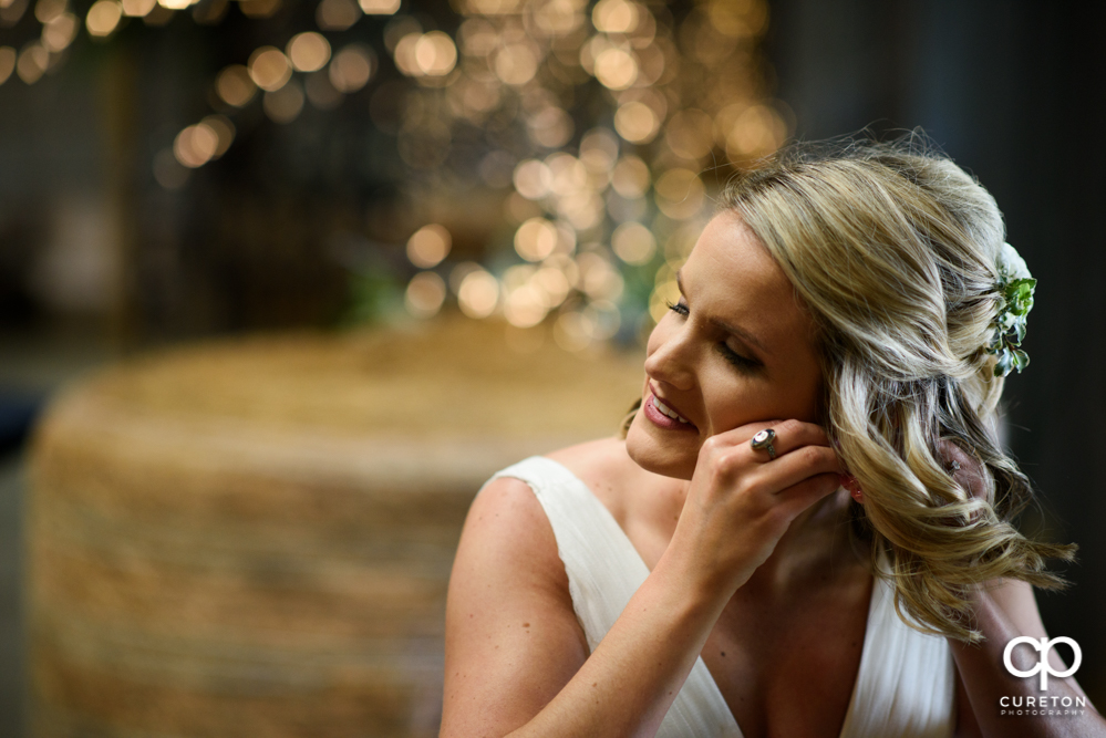 Bride putting earrings on.