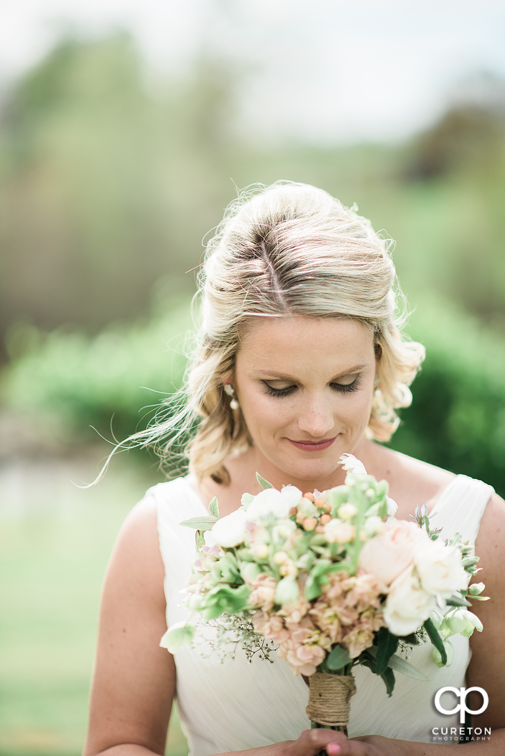 Bride smelling her flowers.