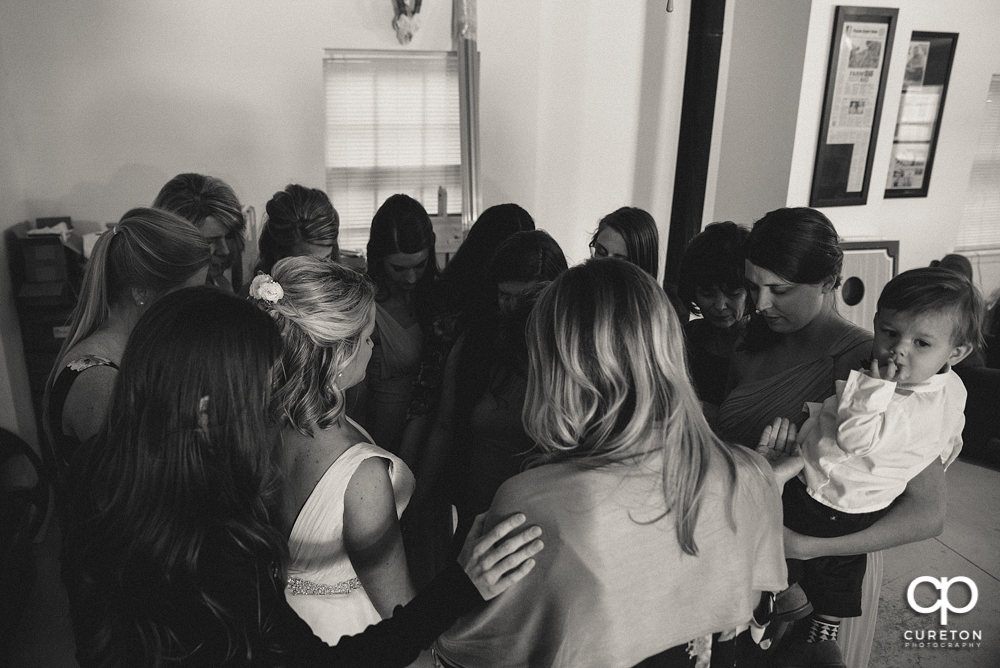 Bride and bridesmaids praying before the ceremony.