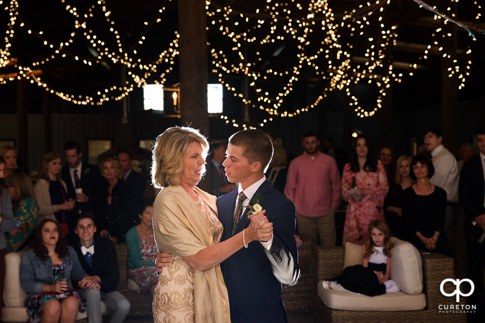 Groom and mother dance at the wedding reception.