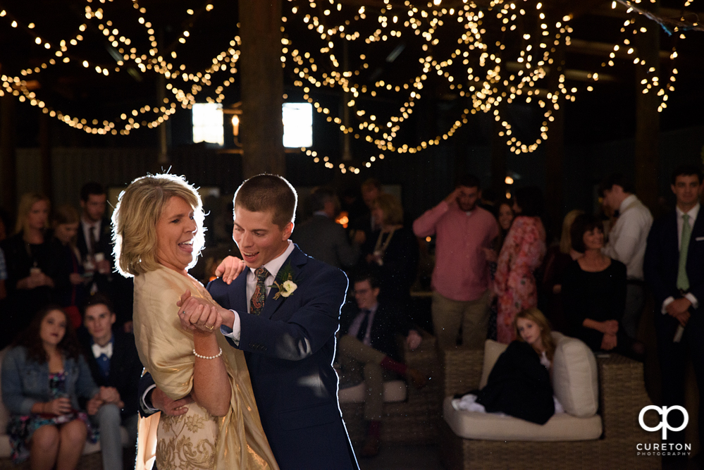 Groom and mother dance at the wedding reception.