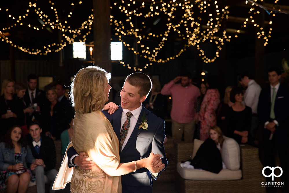 Groom and mother dance at the wedding reception.