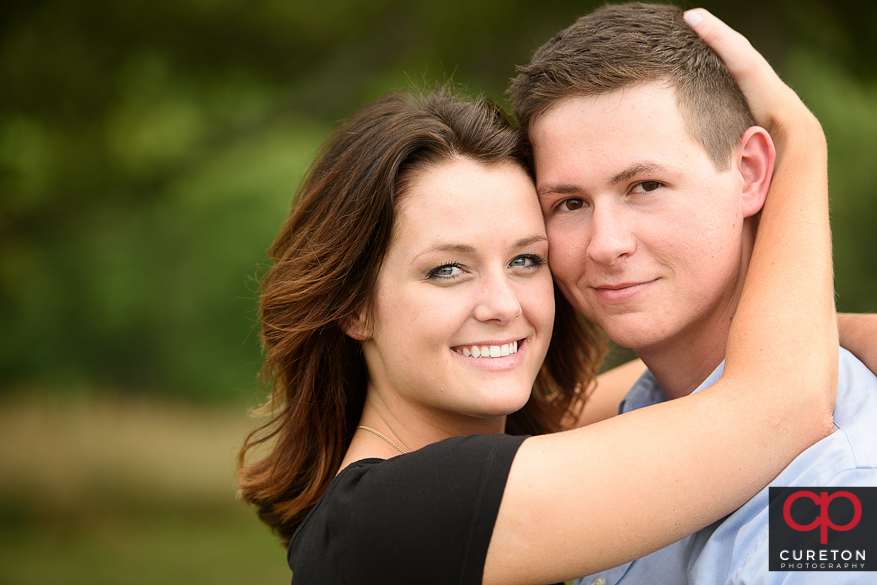 Engaged couple looking directly at teh camera.