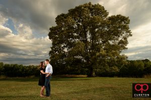 Future bride and groom kissing by the oak tree during a Greenbrier Farms Engagement Session.