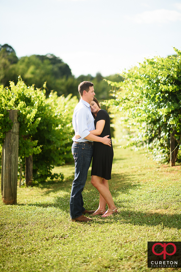 Couple snuggling on a farm during a rustic engagement session.