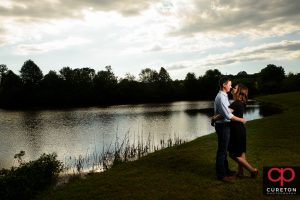 Engaged couple dancing by the lake at Greenbrier Farms.