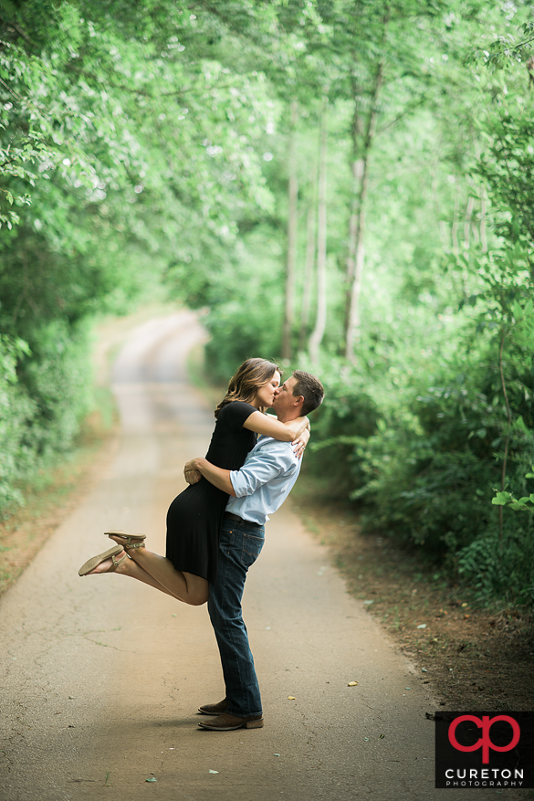 Couple kissing on a farm road.