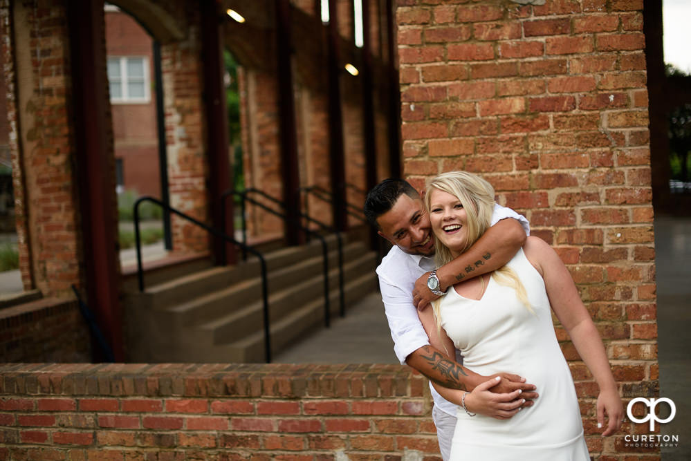 Engaged couple laughing at the Wyche Pavilion.