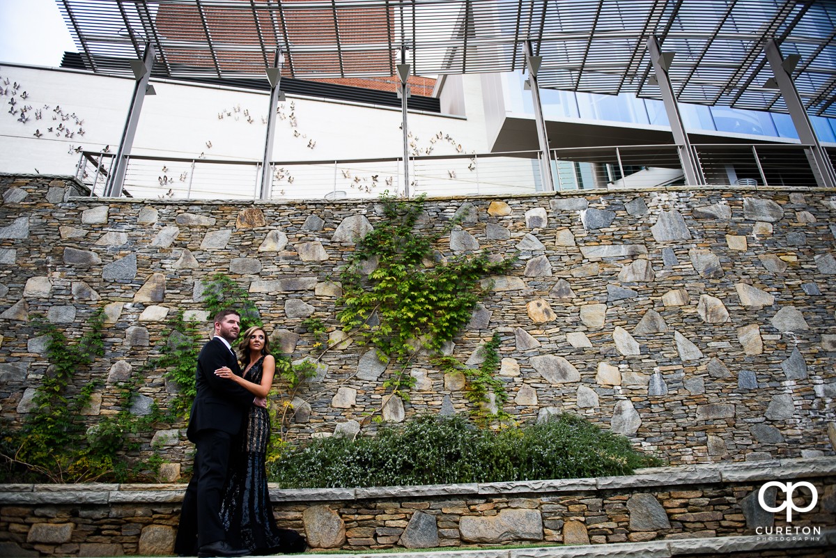 Nicely dressed couple standing on the wall behind the Peace Center in downtown Greenville.