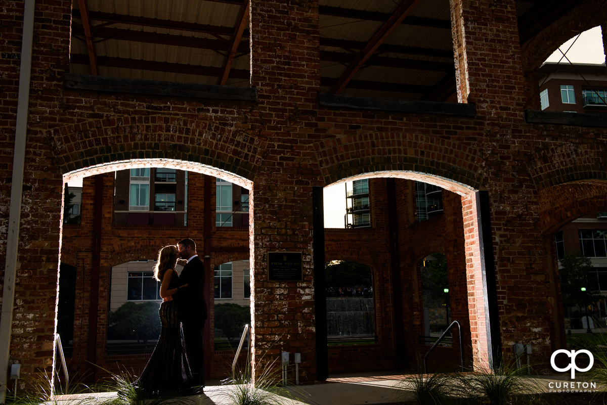 Engaged couple kissing in the window of the Wyche Pavilion behind Larkin's on the River.