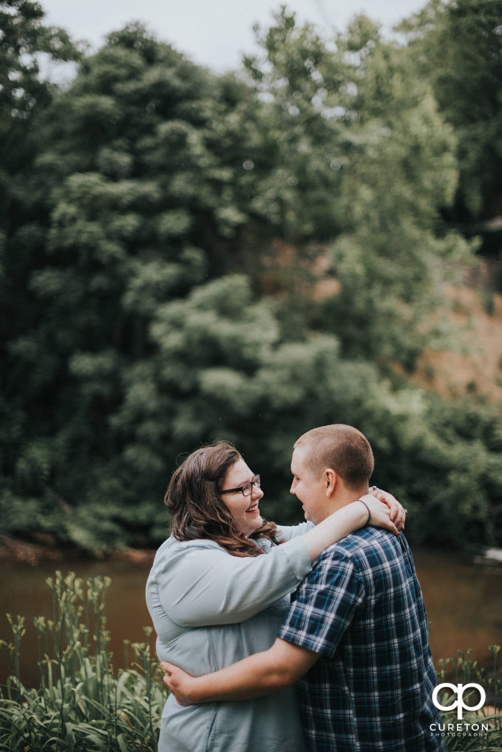 Engaged couple smiling at each other.