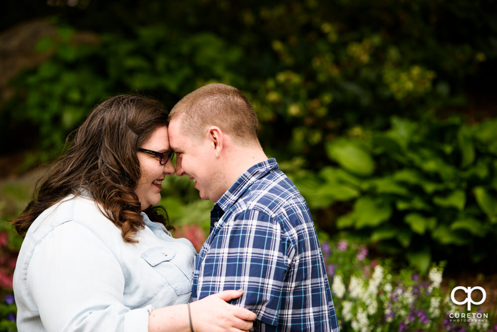 Engaged couple standing facing each other.