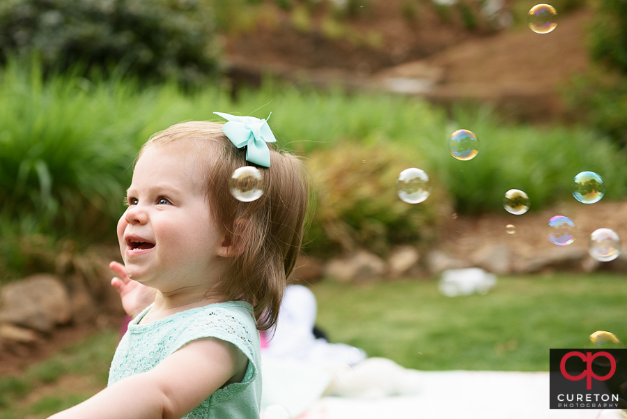 Toddler with bubbles in the park.