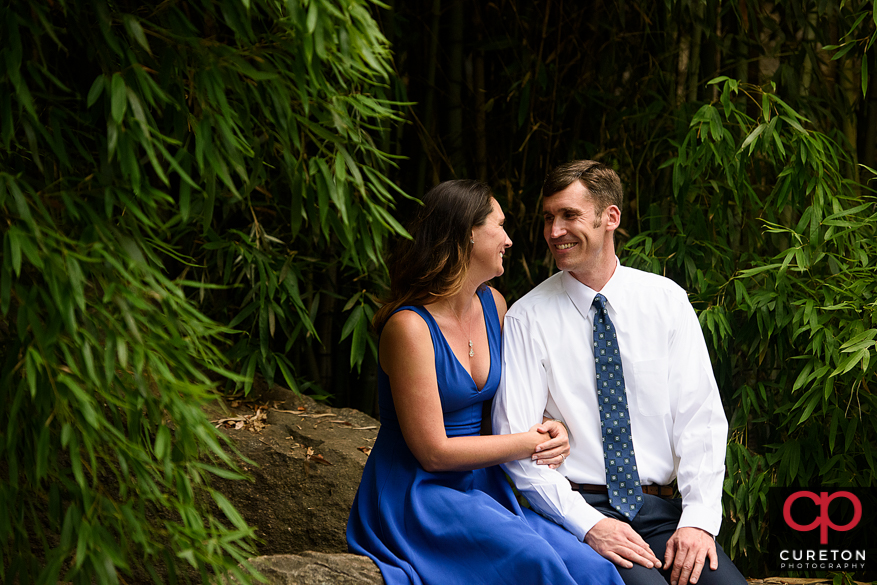 Engaged couple smiling at each other during a Greenville park engagement session.