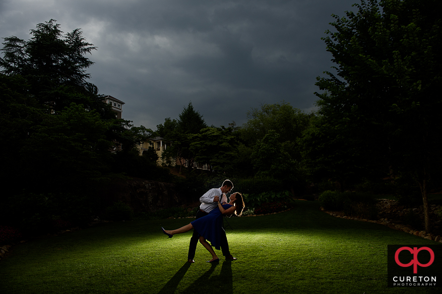 Engaged couple dipping at sunset in a park in downtown Greenville,SC.