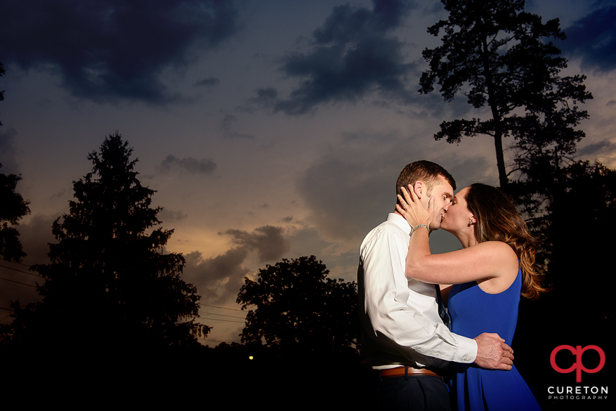Engaged couple kissing at sunset in Greenville,SC.