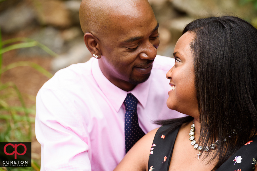 Married couple looking at each other during their anniversary photo session in Greenville,SC at the Rock Quarry Garden.