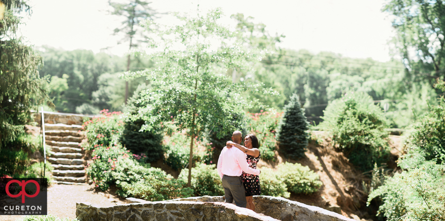 Couple standing on a rock bridge during their anniversary photo session in Greenville,SC at the Rock Quarry Garden.
