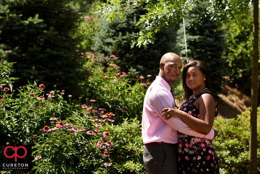 Married couple having fun during their anniversary photo session in Greenville,SC at the Rock Quarry Garden..