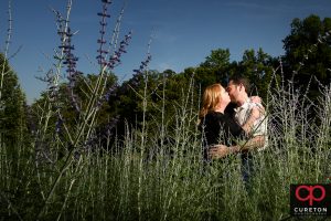 Engaged couple standing in a field.