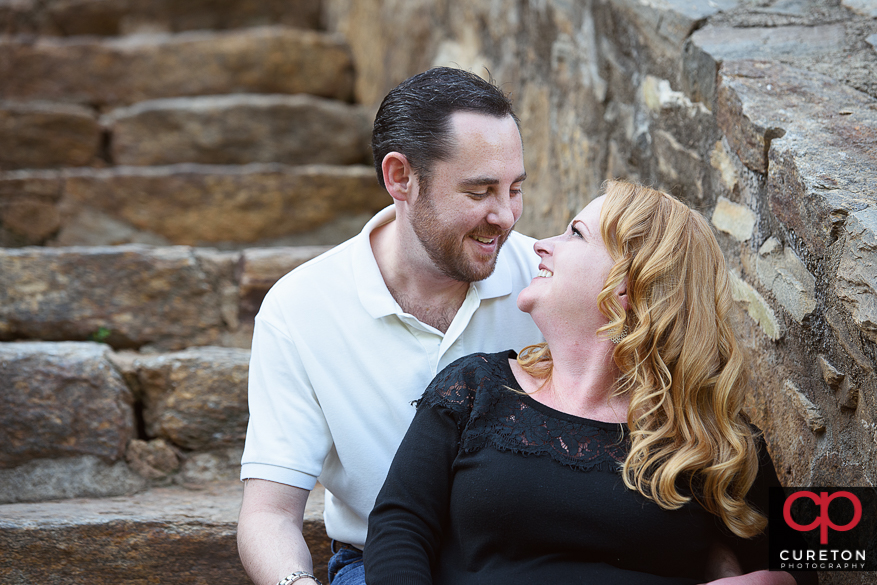 Engaged couple sitting on the steps.