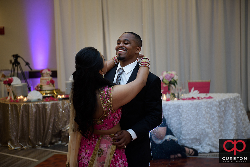 Indian bride and groom sharing a first dance at their reception.