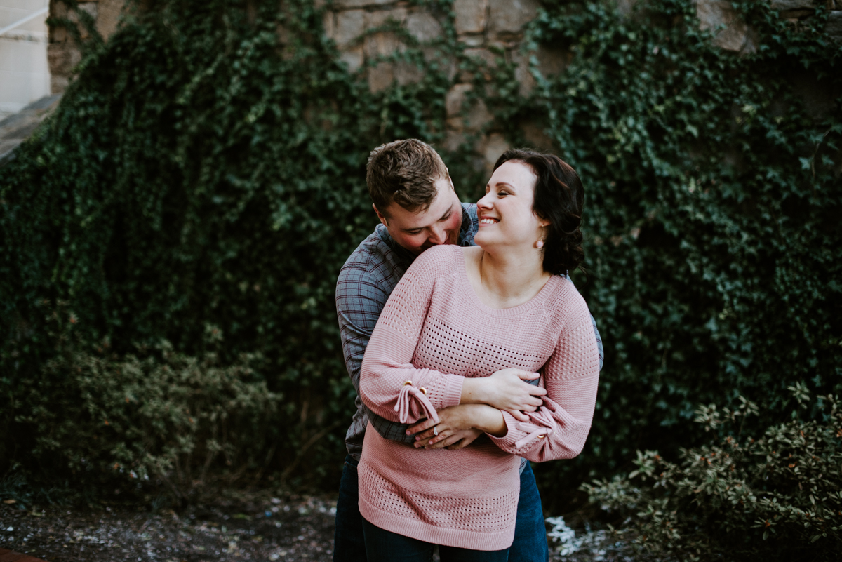 Couple hugging outside of the Courtyard Marriott during their January Engagement Session in downtown Greenville,SC.
