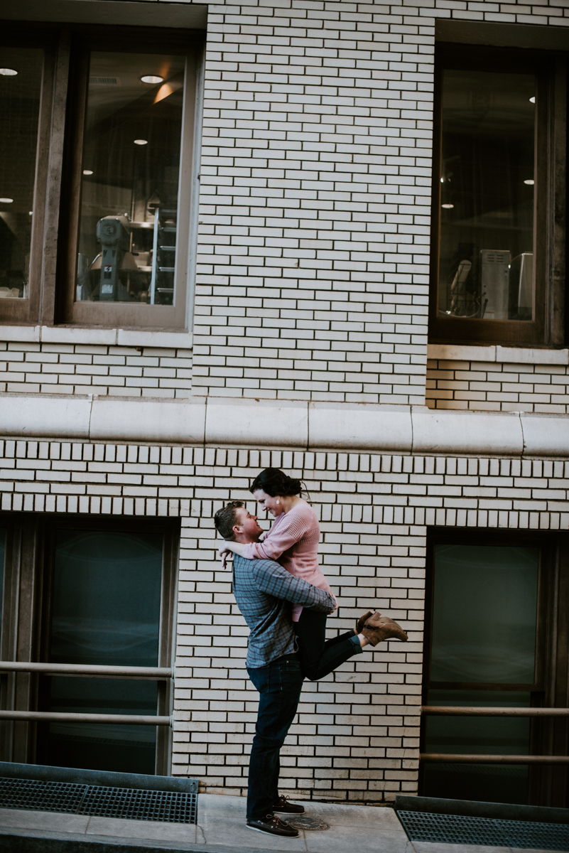 Groom lifting his bride outside of the Westin Poinsett in downtown Greenville during an engagement session.