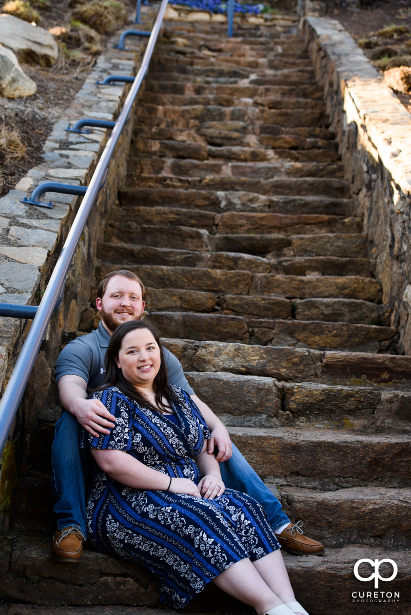 Engaged couple sitting on some rock steps during a Greenville,SC park engagement session.