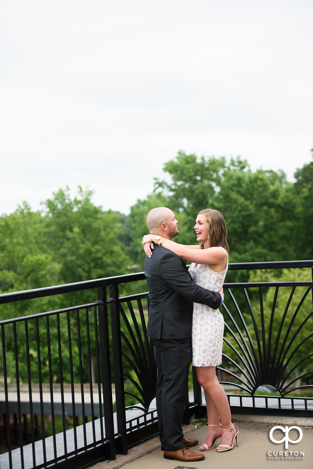 Engaged couple hugging at their wedding rehearsal dinner at the Thornblade Country Club in Greenville , SC .