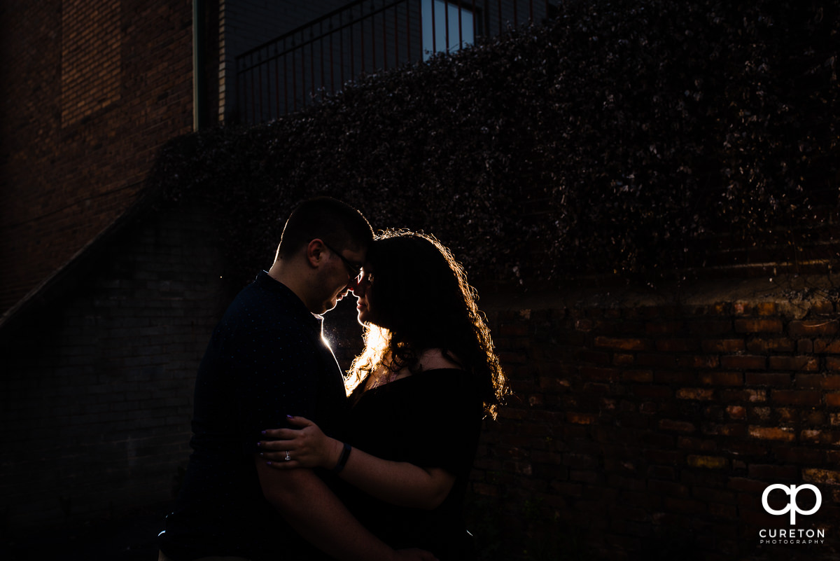 Man and his fiancee hugging during a spring engagement session in downtown Greenville ,SC.