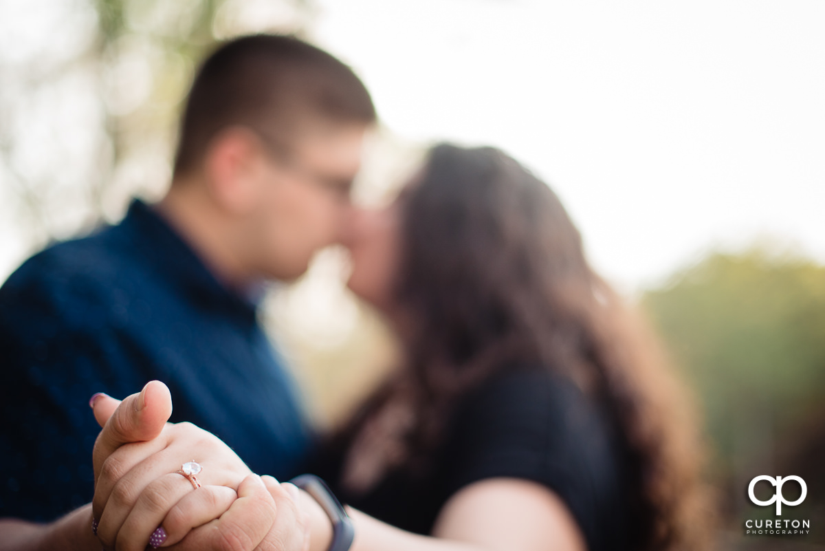 Engaged couple showing off the ring.