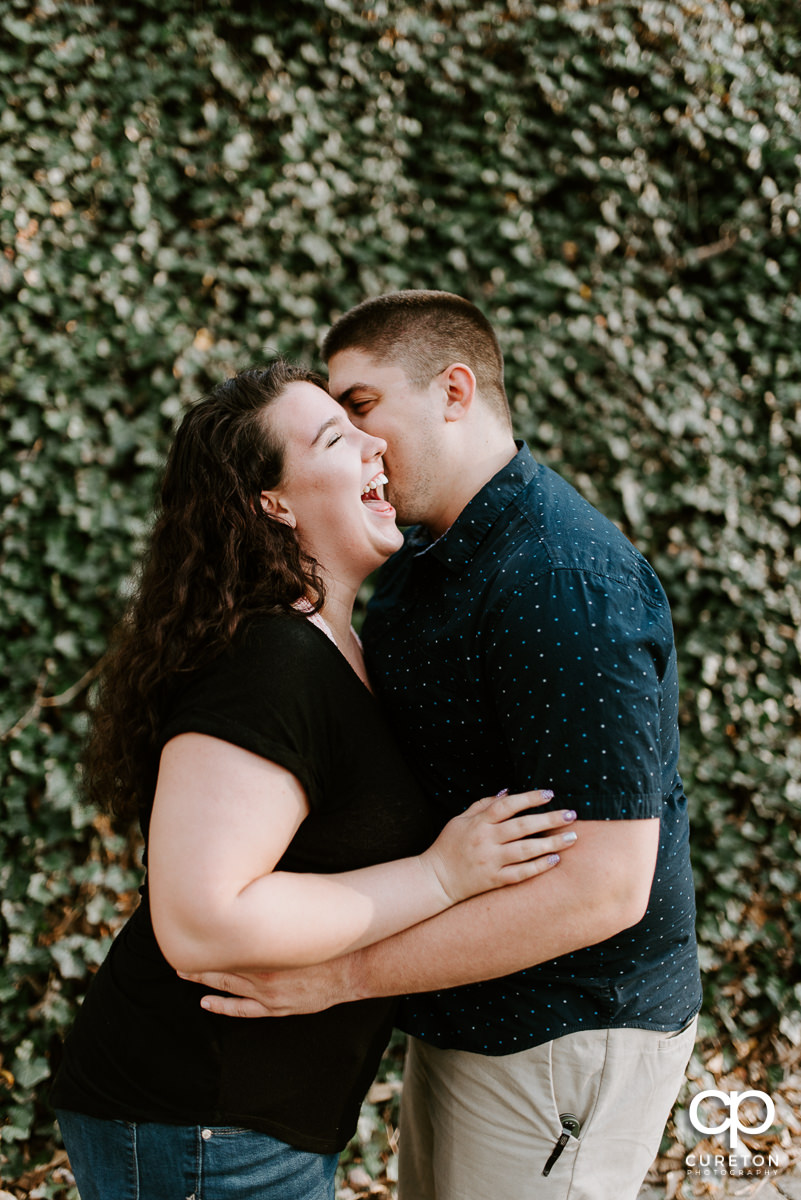 Groom making his future bride laugh spring engagement session in downtown Greenville ,SC.