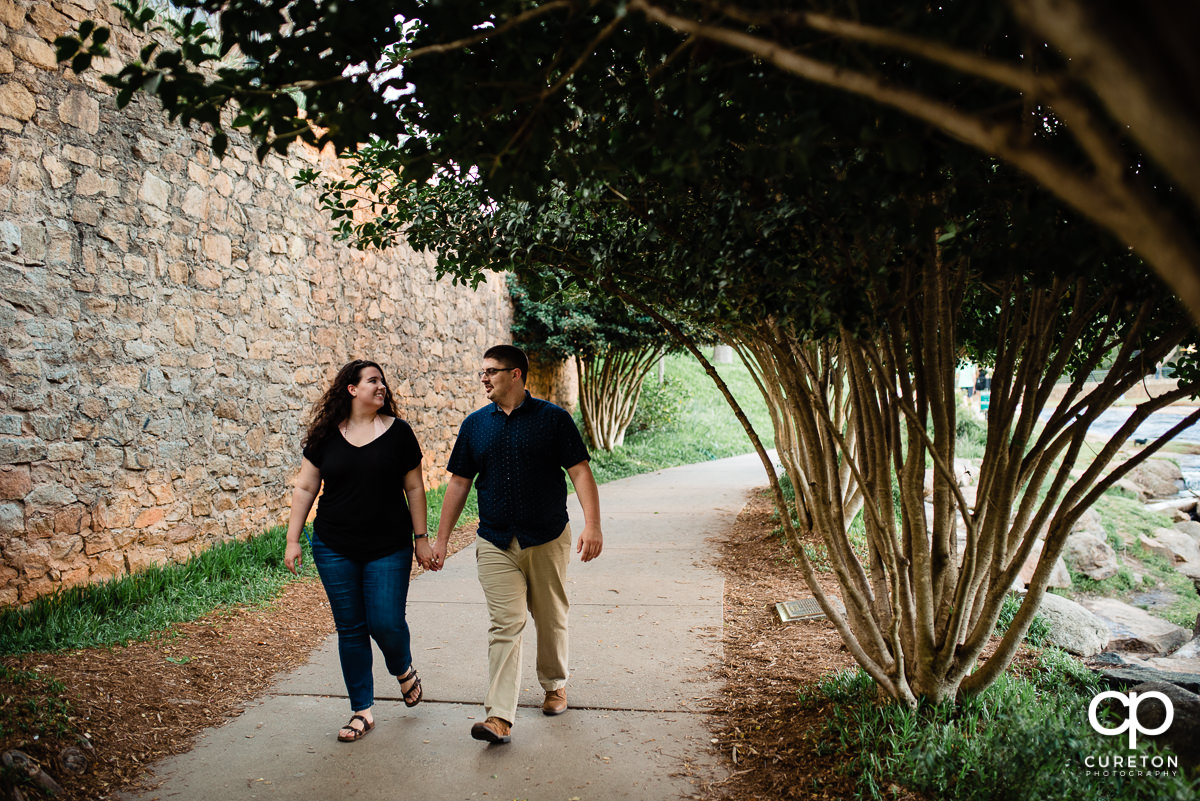 Engaged couple walking in Falls Park.