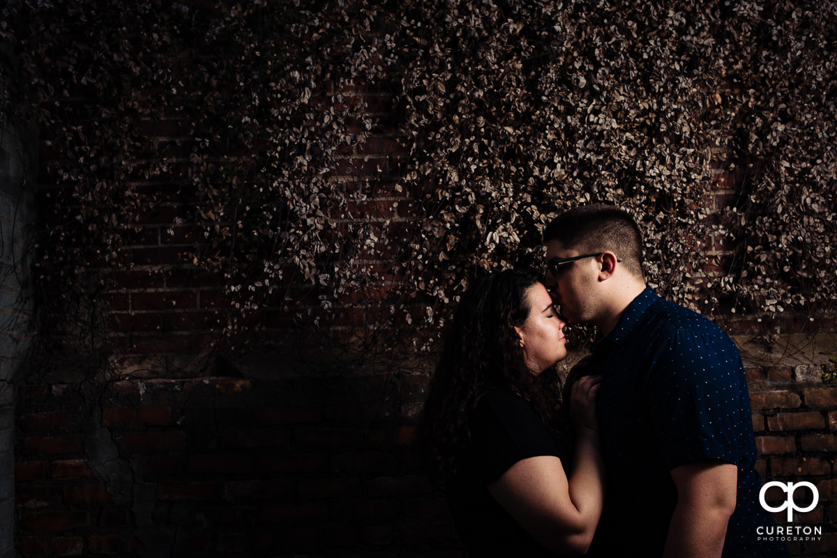 Man kissing his future bride on the forehead.