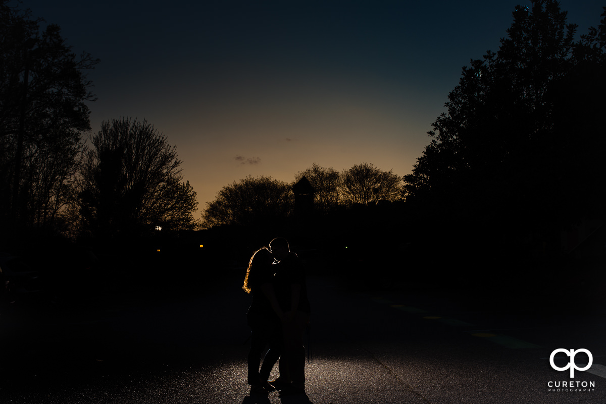 Engaged couple silhouette in the park at sunset.