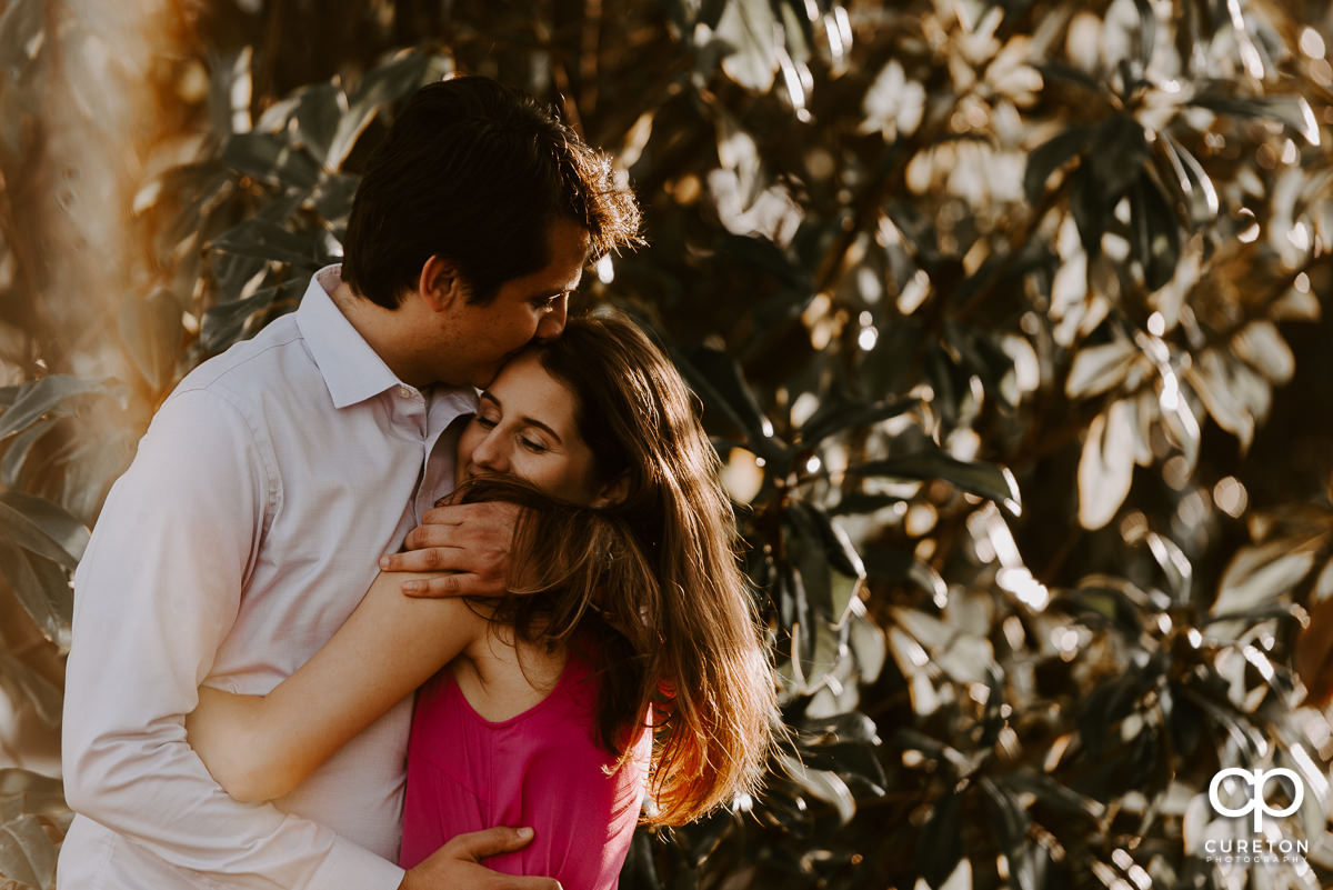 Couple hugging during their engagement session in downtown Greer,SC.