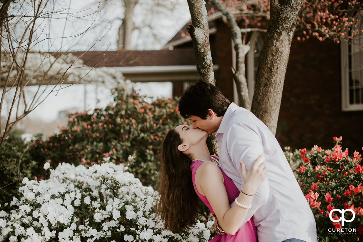 Man kissing his fiancee during their downtown Greer engagement session.