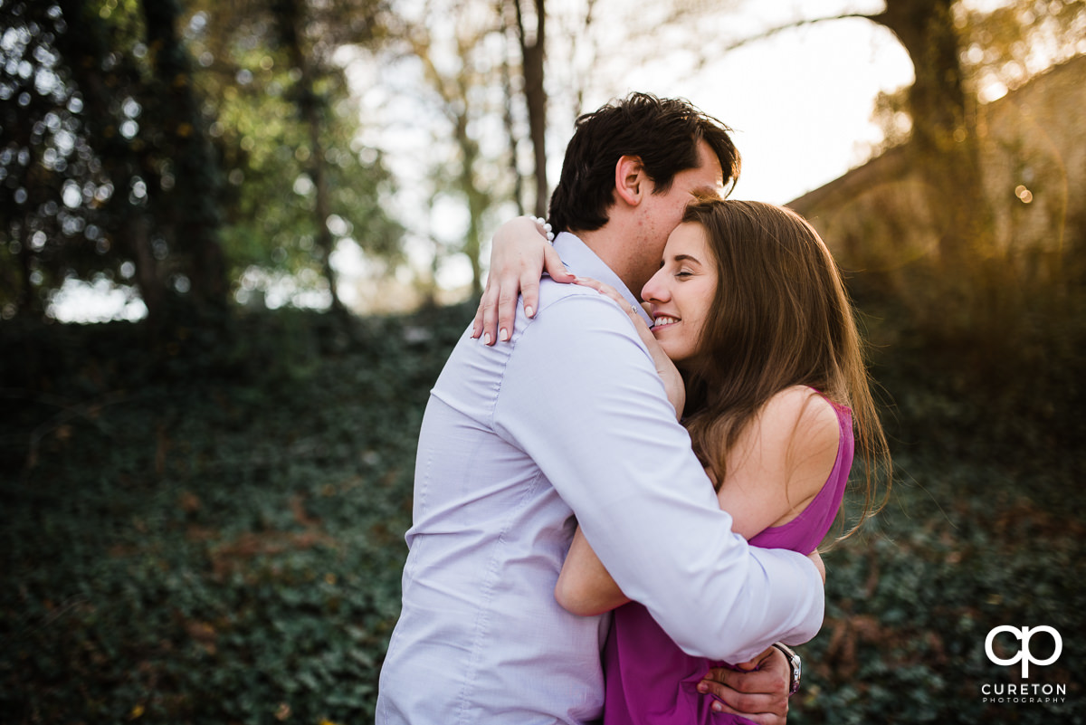 Engaged couple playing in Greer City Park.