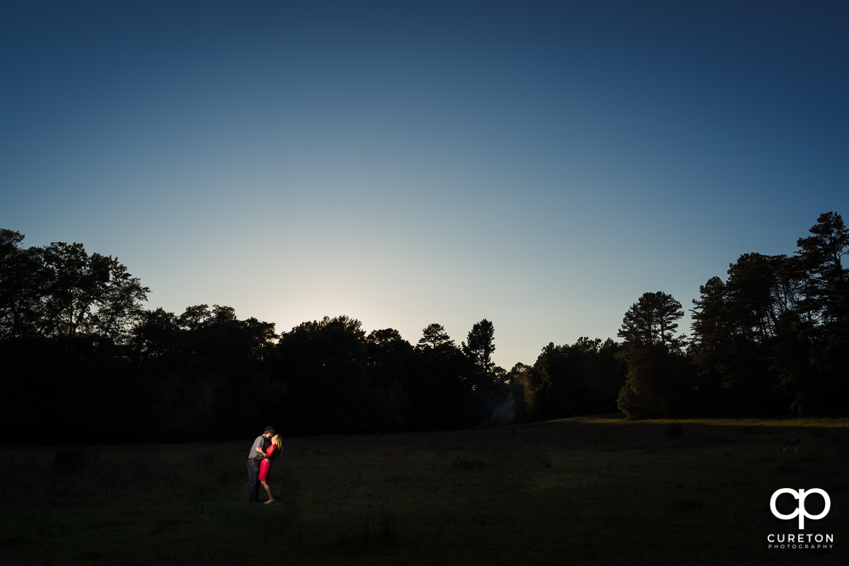 Engaged couple in a field at sunset during a summer engagement session in Greer,SC.