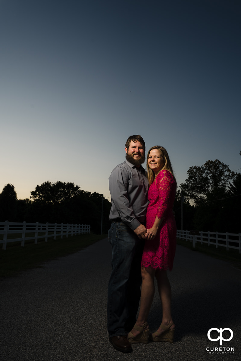 Engaged couple standing in the middle of the road during a summer engagement session in Greer,SC.