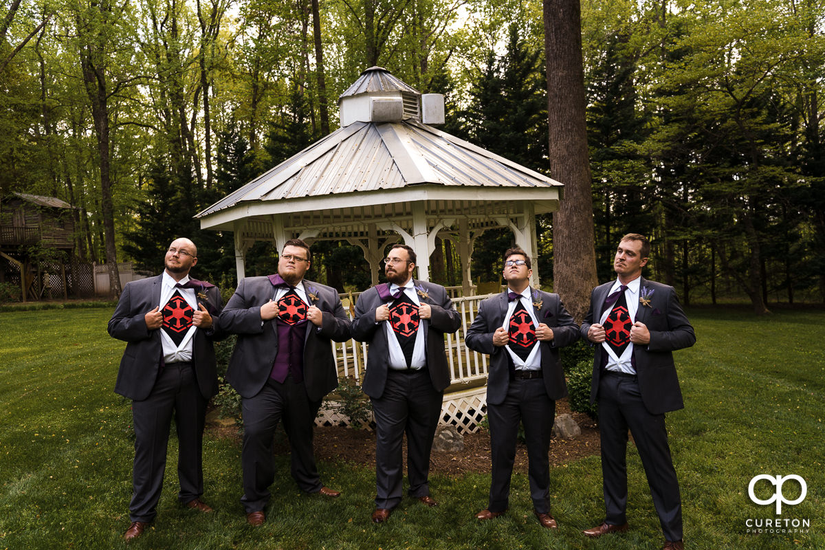 Groomsmen opening their formal shirts to reveal Star Wars imperial shirts.