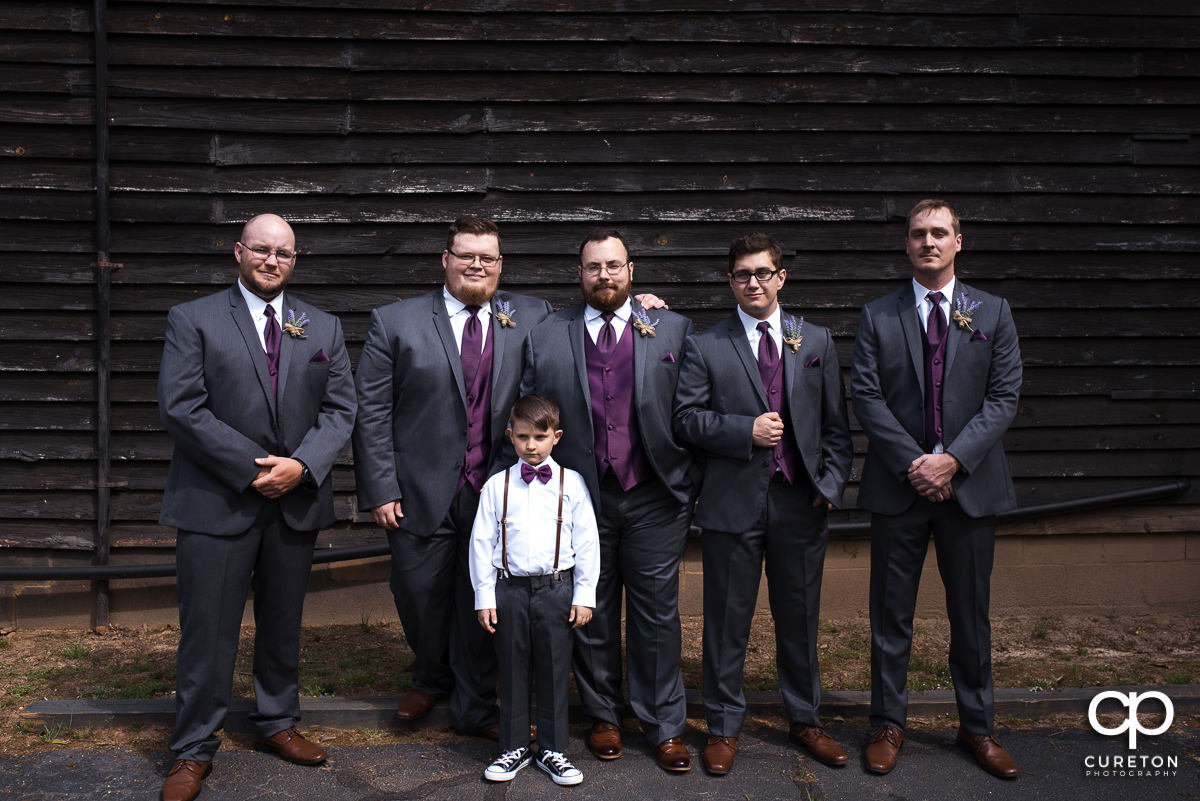 Groom and groomsmen in front of a barn.