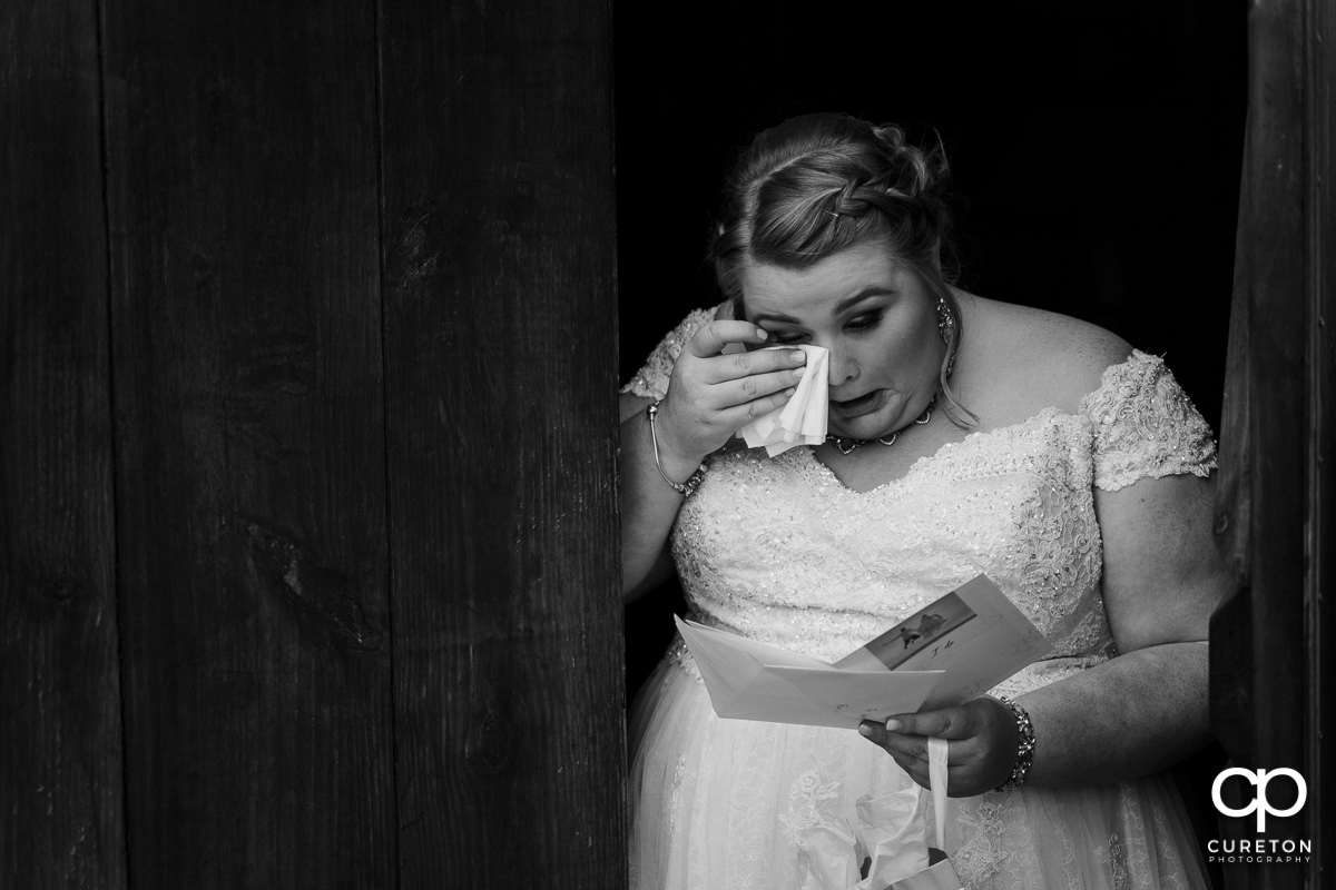 Bride crying reading a letter from the groom.
