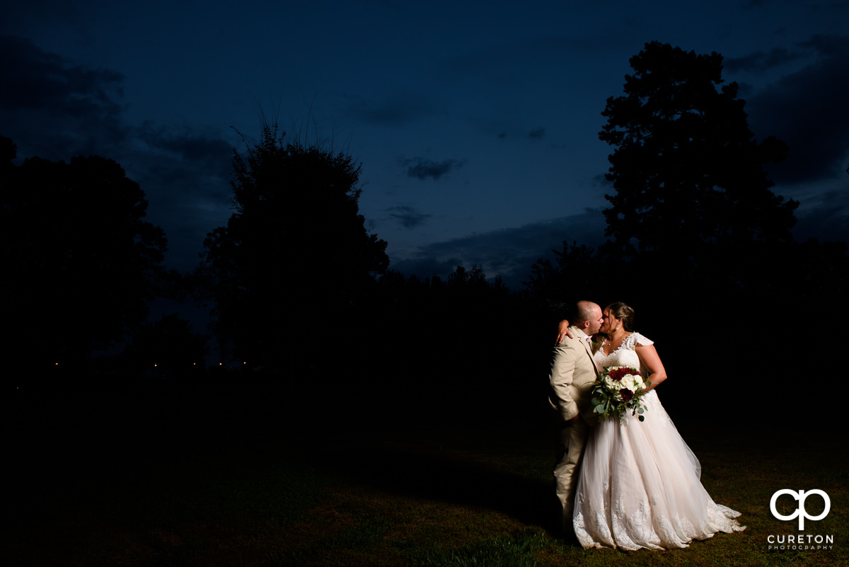 Bride and groom kissing at sunset during their wedding at The Grove at Pennington.