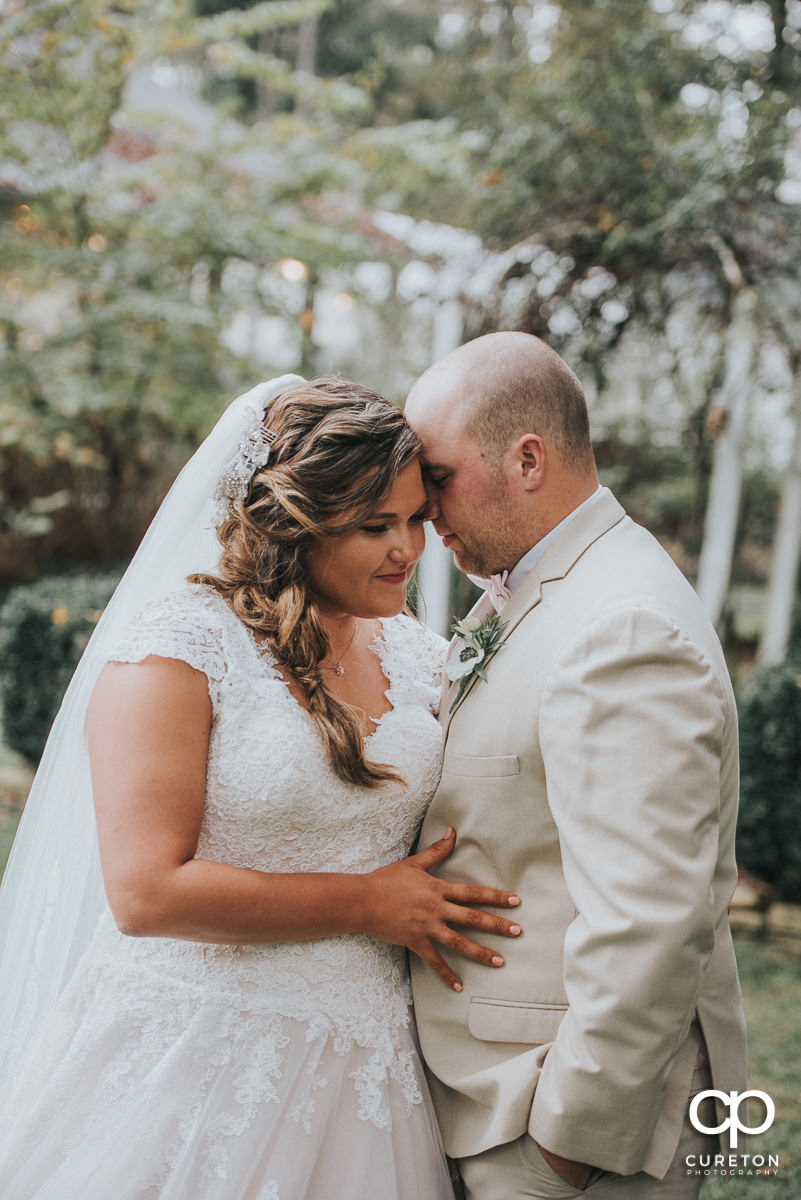 Bride and groom posing after a first look before their wedding ceremony atThe Grove at Pennington.