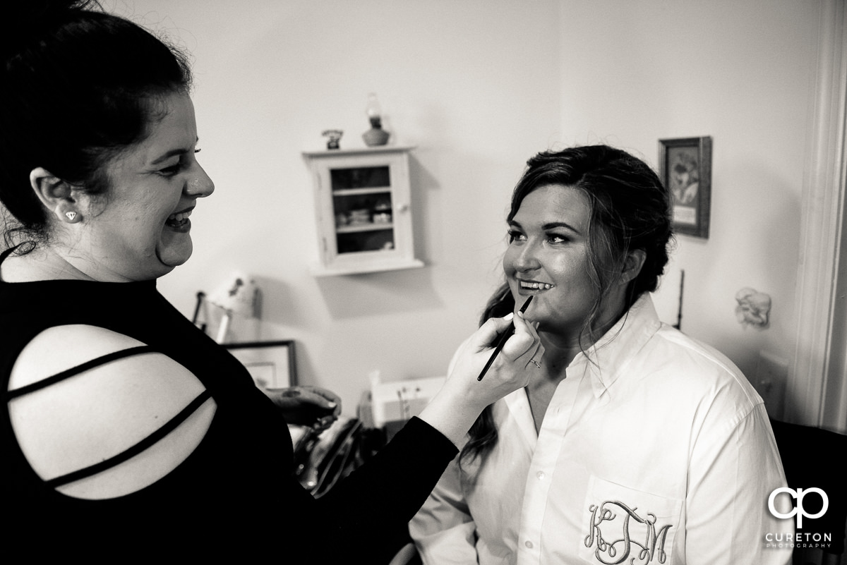 Bride applying lipstick.