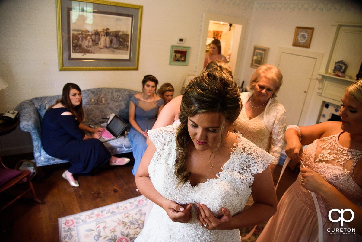 Bride putting her dress on before the wedding.